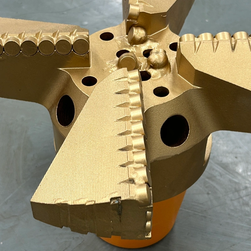 Close-up of four-wing concave PDC drill bit showing cutting structure and cutter arrangement